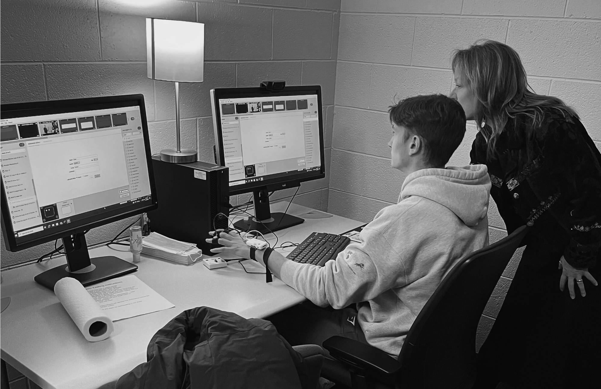 Student and teacher working on a computer together